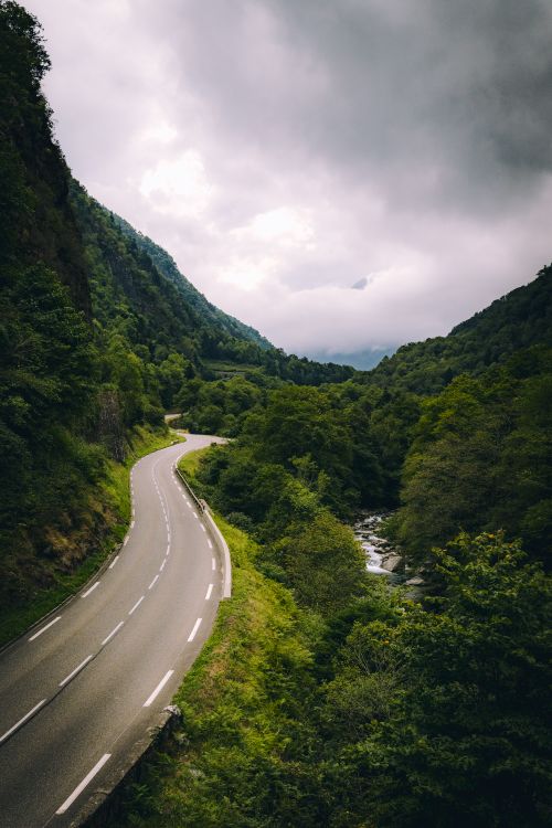 Free A winding road in Cauterets, Occitanie, France, surrounded by lush green mountains. Stock Photo