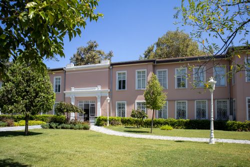 Free A tranquil garden with a historic building in Istanbul, Türkiye, under clear blue skies. Stock Photo
