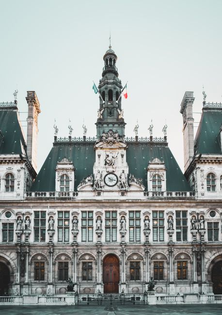 Front view of the historic Hôtel de Ville with French flag, Paris architecture.