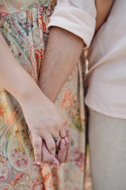 Free A couple holding hands showcasing love and fashion with unique bohemian style clothing. Stock Photo