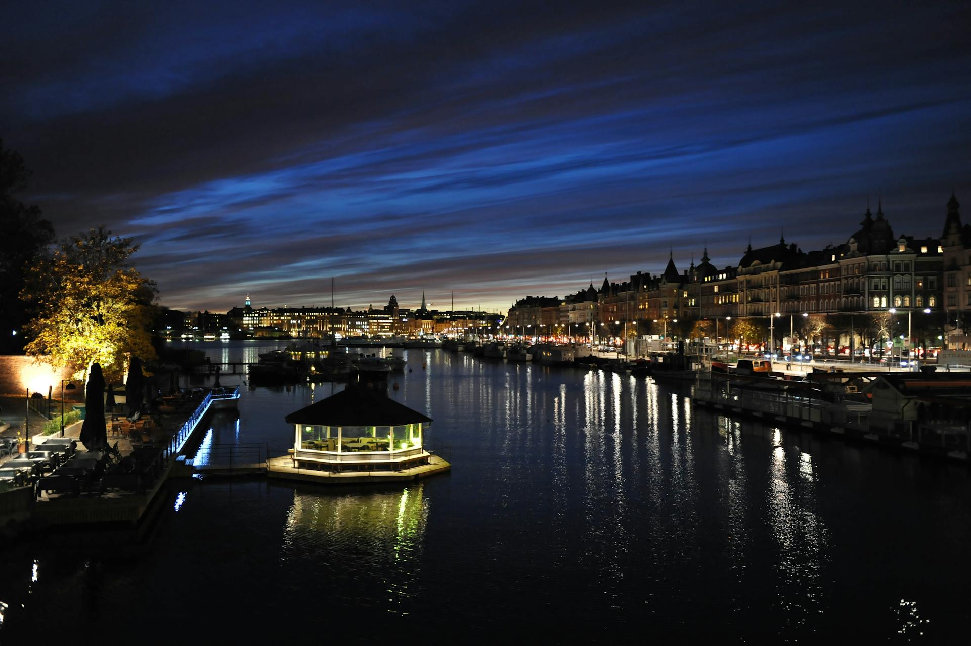 Beautiful nighttime view of Stockholm's waterfront with illuminated cityscape and reflections.