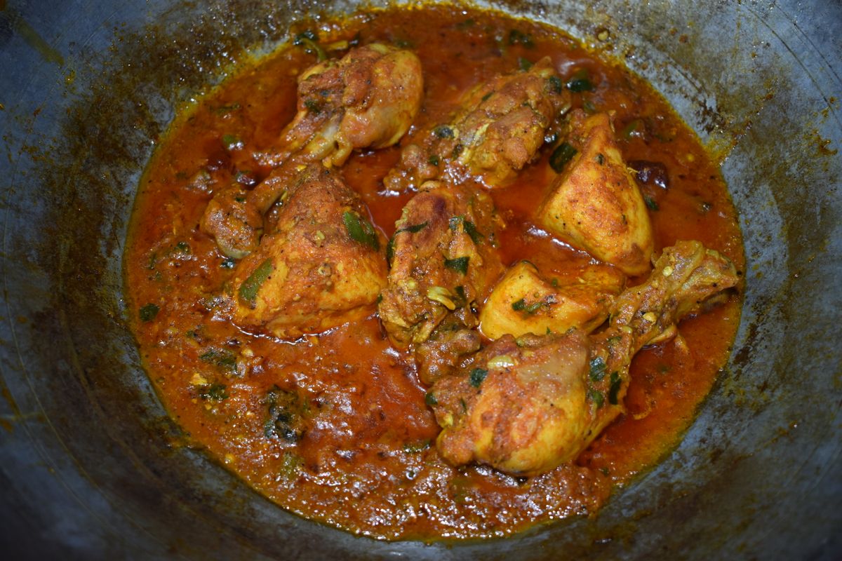 Spicy chicken curry simmering in a traditional karahi