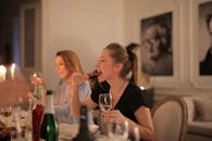 与朋友在室内欢乐地享用葡萄酒和食物的晚宴