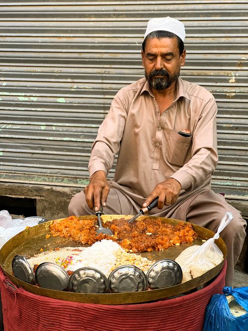 Free Street vendor in Mingora, Pakistan, preparing traditional sweets and halwa. Stock Photo