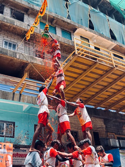 Free A vibrant depiction of the Dahi Handi festival with a human pyramid breaking the pot. Stock Photo
