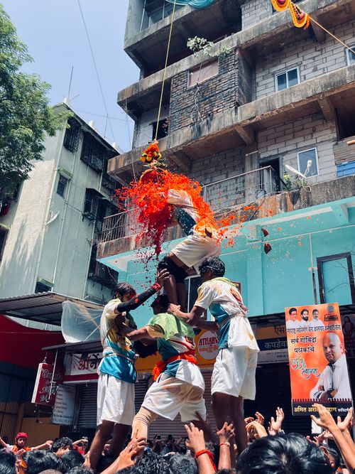 Free Men forming a human pyramid during a vibrant Dahi Handi festival in Mumbai, India. Stock Photo