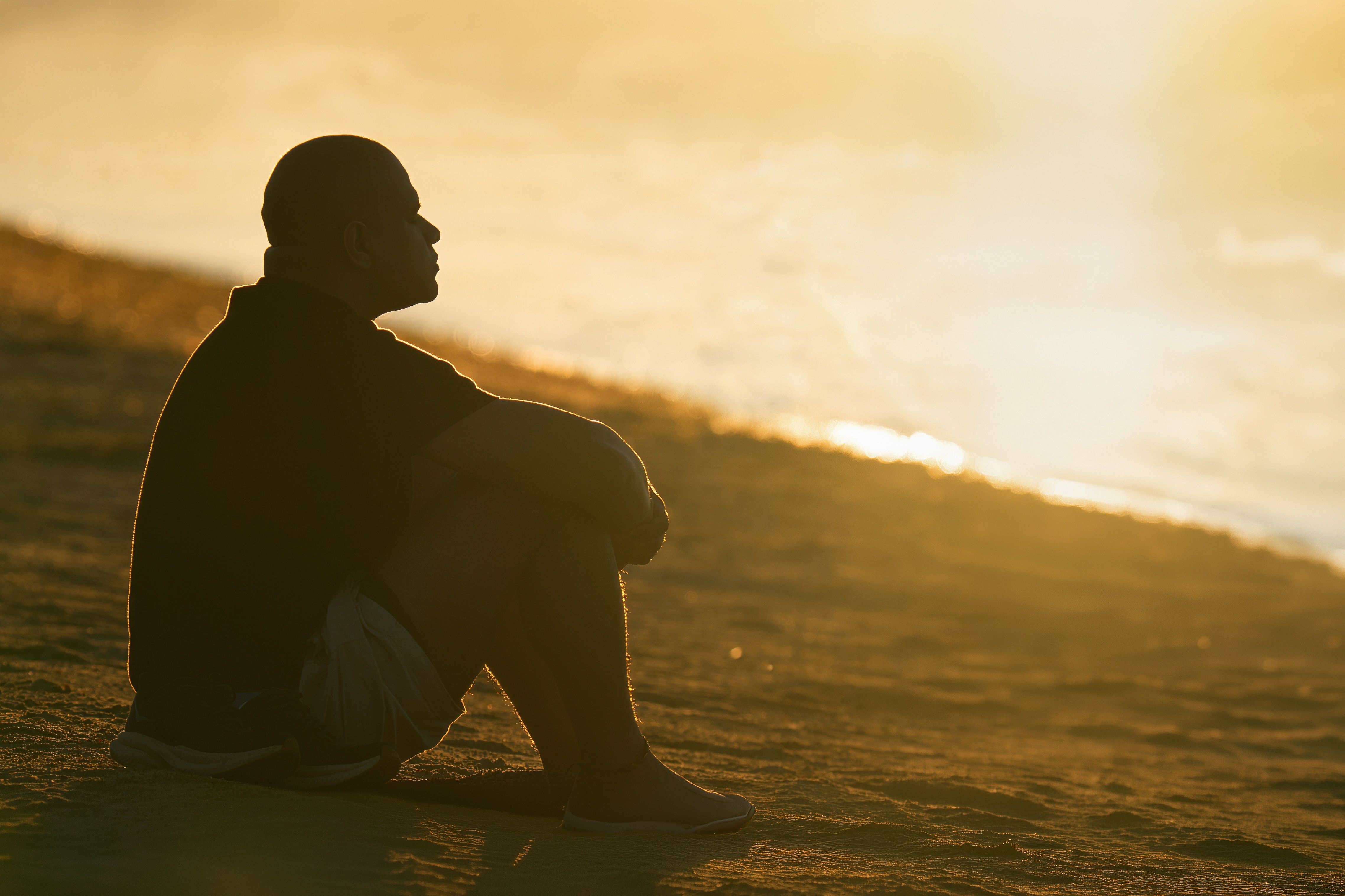 Silhouette of a man reflecting by the ocean at sunrise in Stamford, Connecticut.