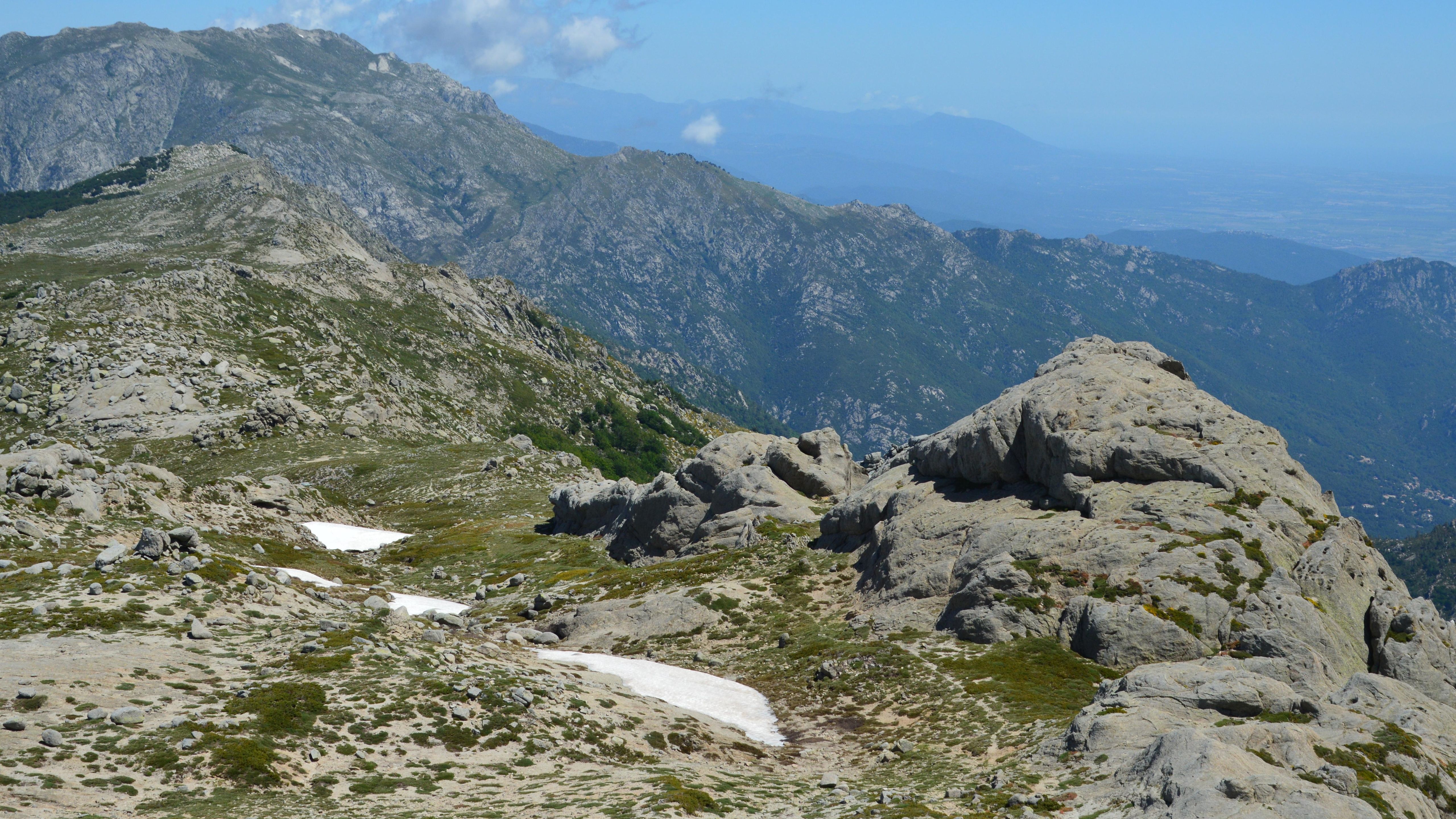 Stunning landscape of rugged mountains in Aullène, Corsica with clear blue skies.