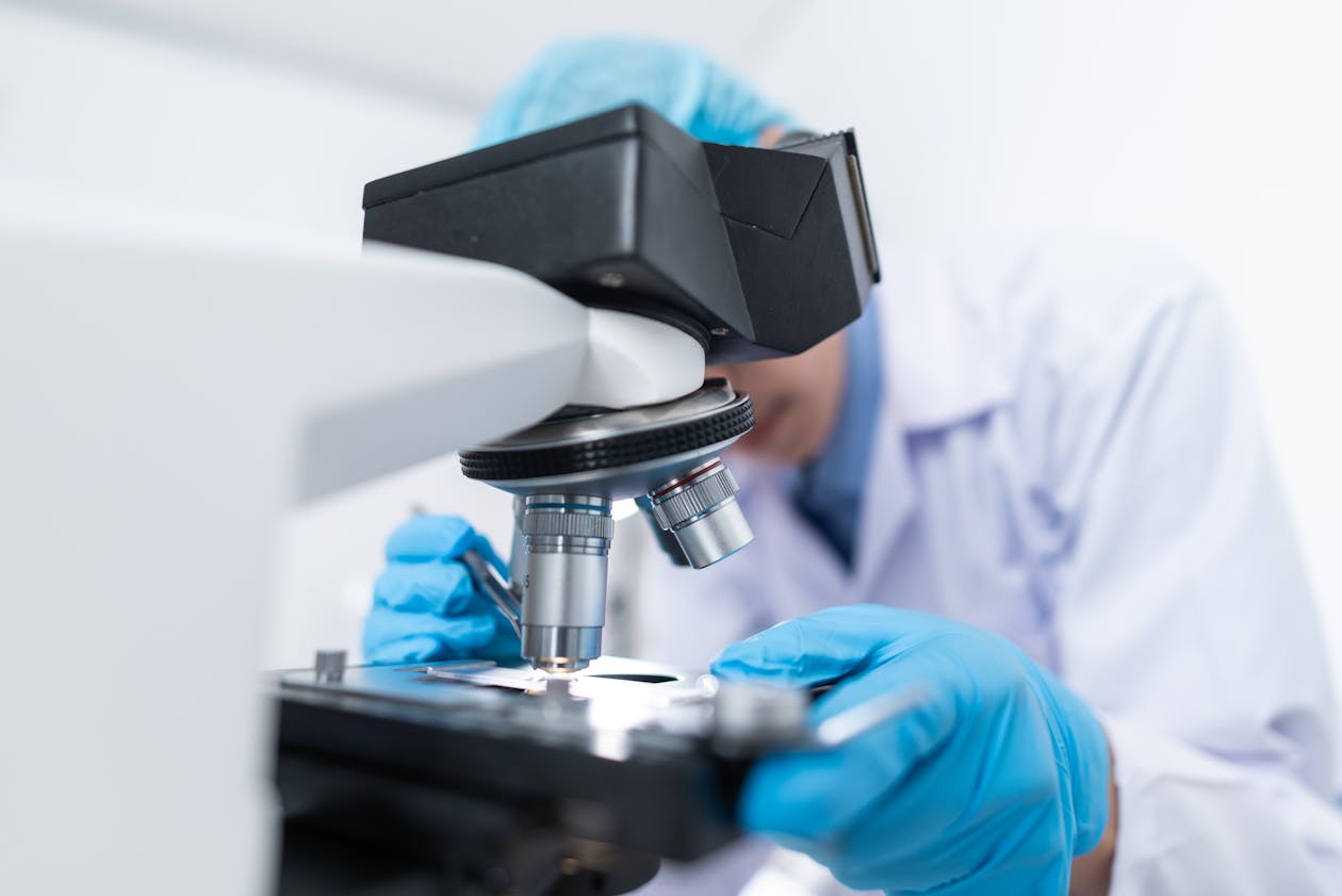 Scientist examining samples through microscope in research laboratory
