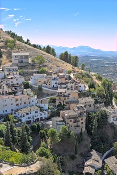 Scenic aerial view of a tranquil Mediterranean hilltop village with lush greenery.
