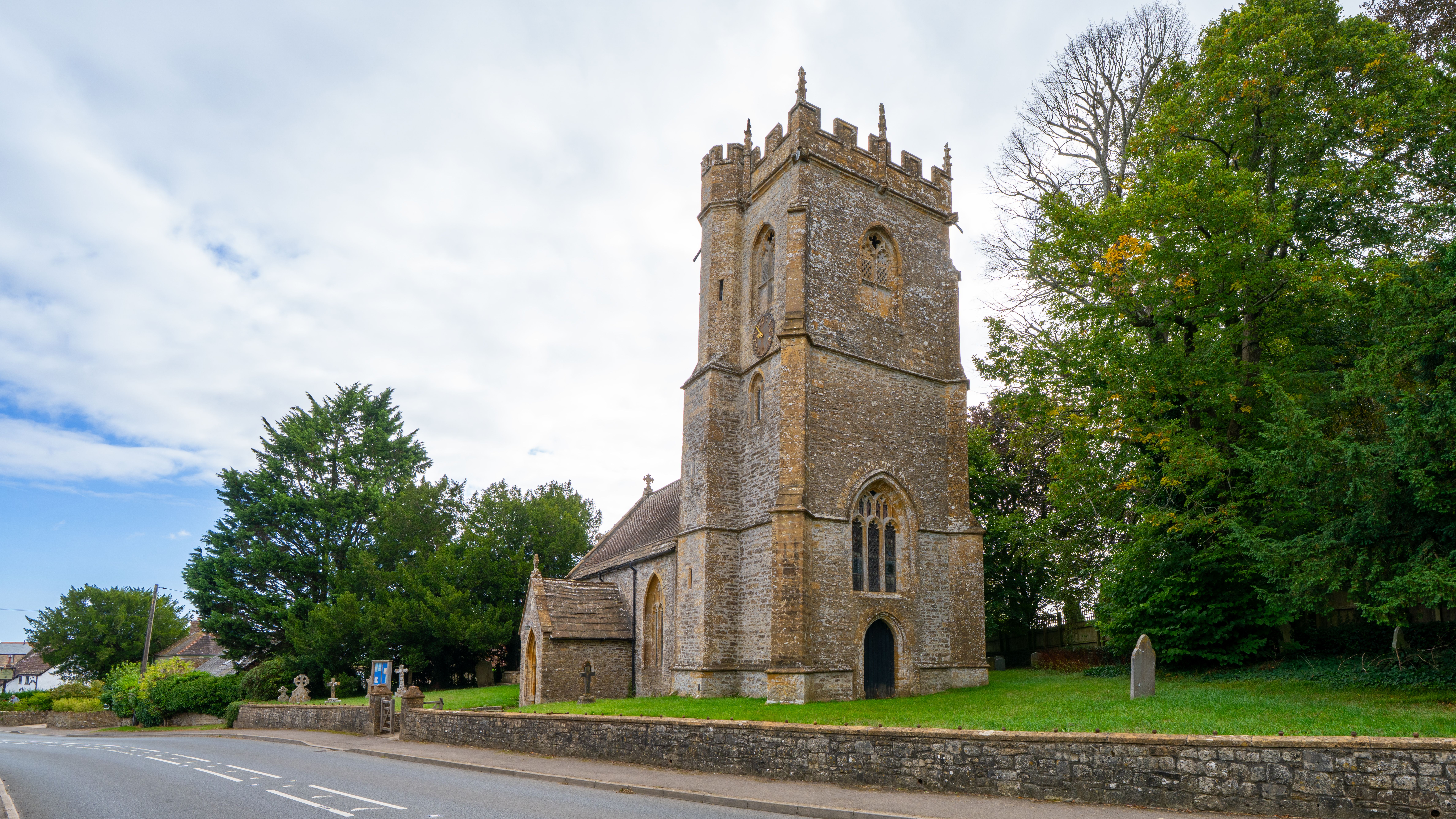 A picturesque stone church tower in a peaceful Dorset village setting.