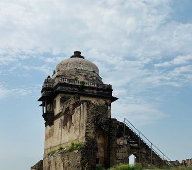 A historical tower with a dome under a bright sky in Pakistan.