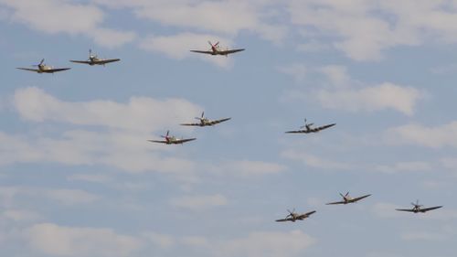 Free Group of vintage fighter planes in formation against a clear blue sky. Stock Photo