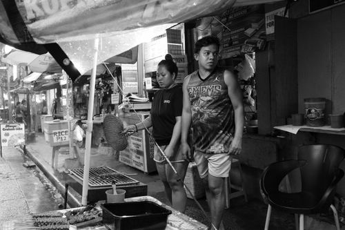 Free Monochrome capture of street food vendors in a busy indoor market setting. Stock Photo