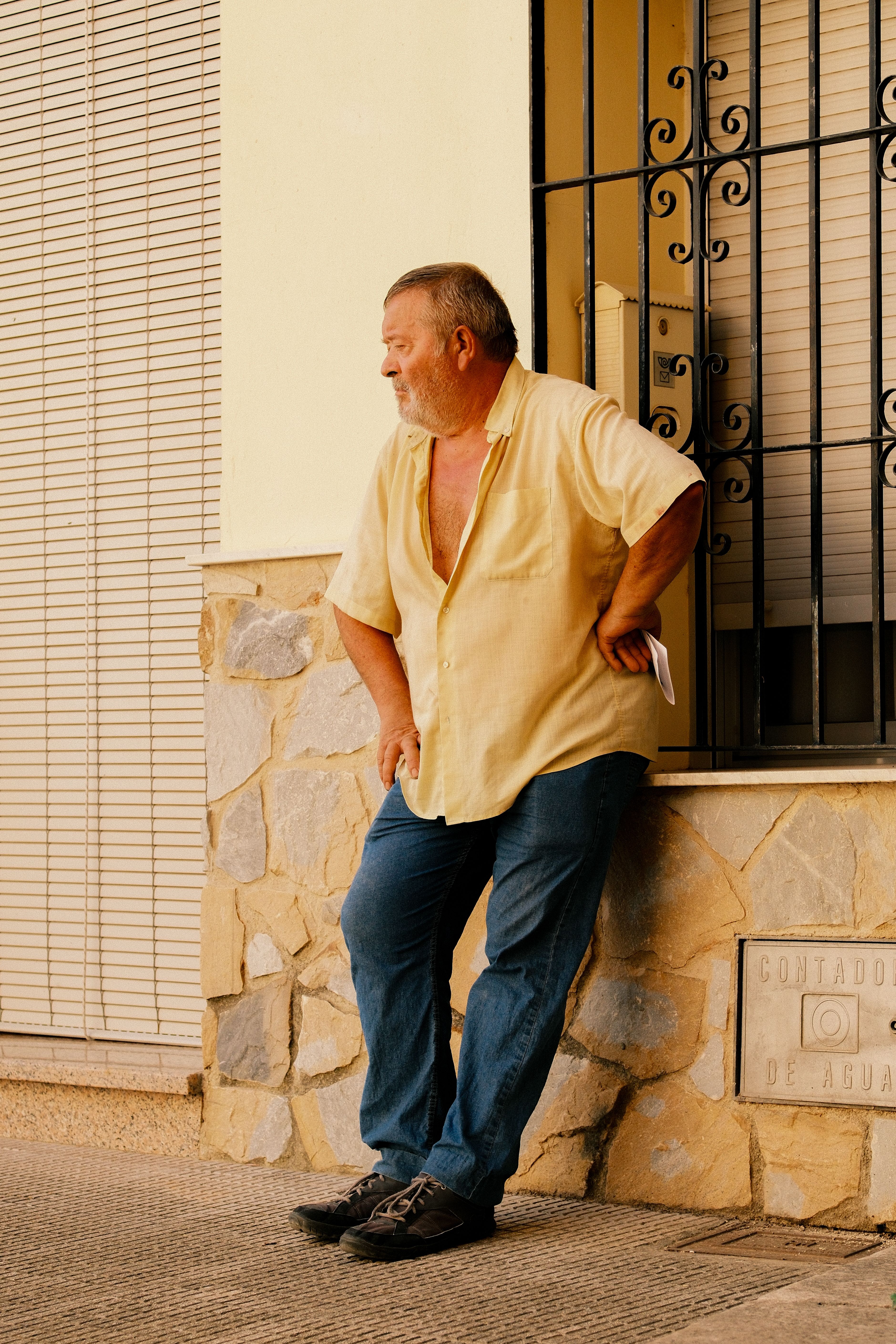 Casual portrait of a man leaning against a stone wall in Planes, Spain.