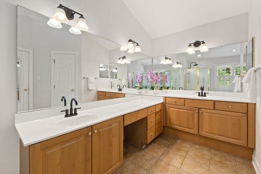 Spacious bathroom featuring double vanity with mirrors and elegant lighting for a contemporary look.