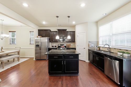 Free Spacious kitchen with modern appliances, center island, and adjacent dining area. Stock Photo
