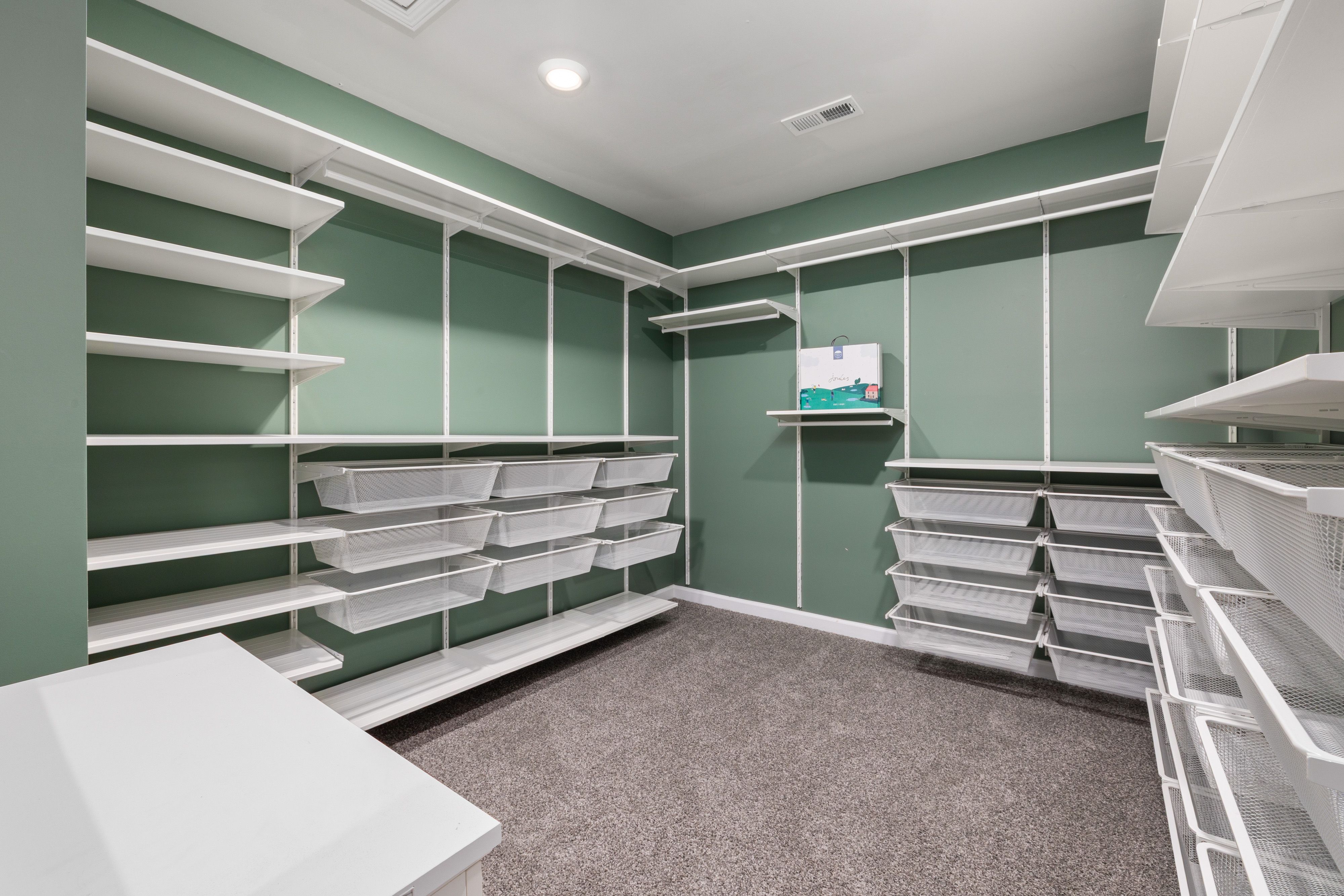 Spacious walk-in closet featuring modern white shelving and ample storage space.