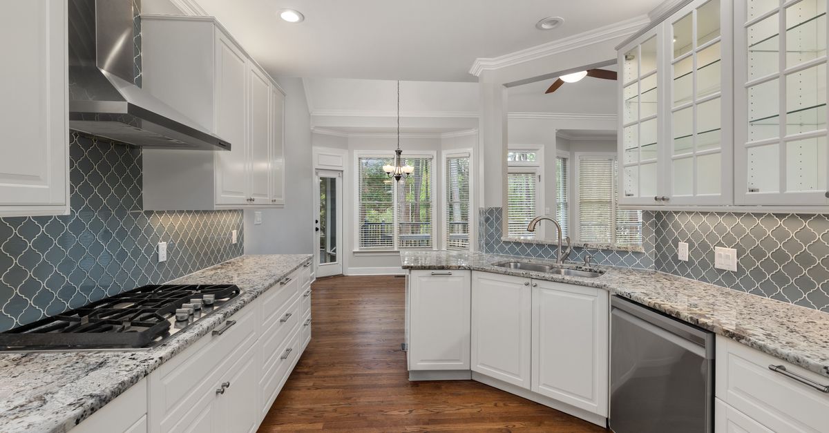 Spacious kitchen featuring granite countertops, hardwood floors, and elegant cabinets.
