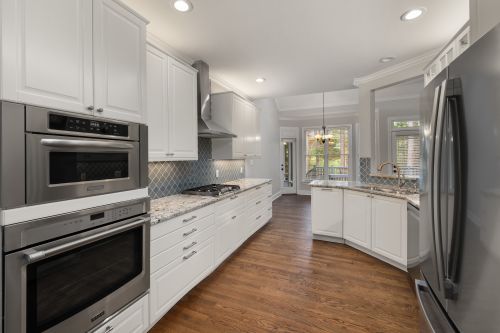 Free Spacious modern kitchen with white cabinetry and stainless steel appliances. Stock Photo