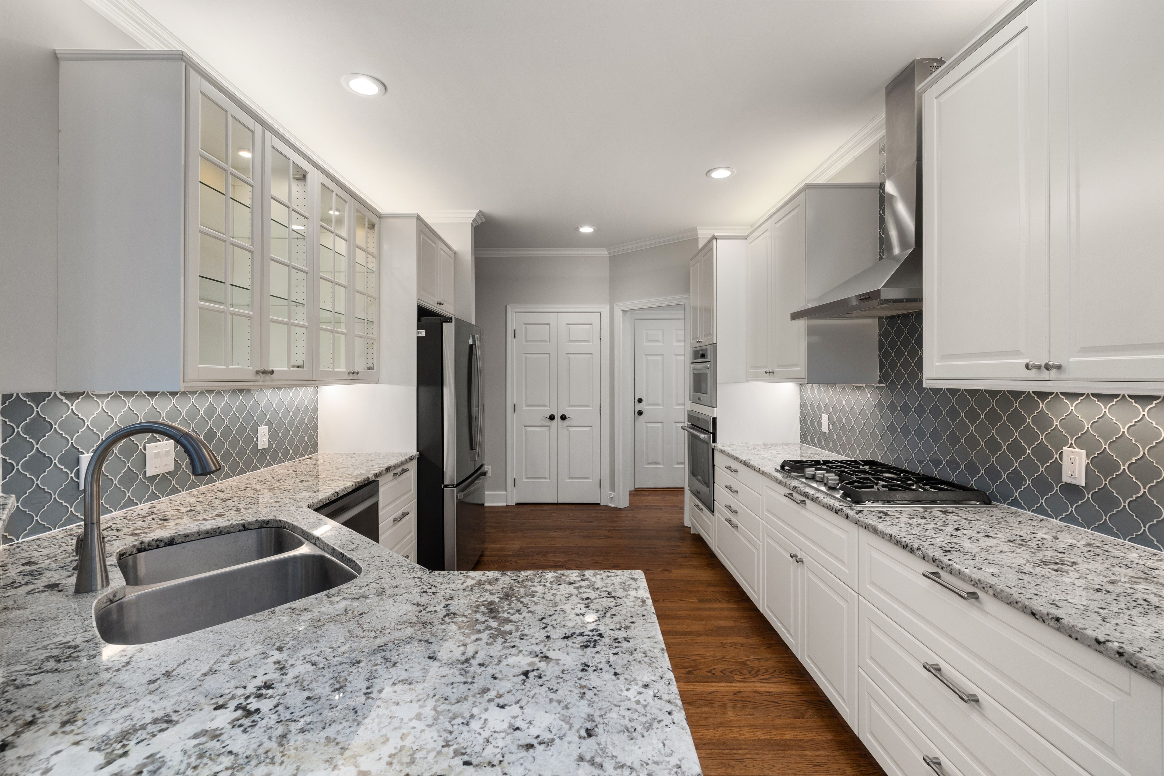 Bright modern kitchen featuring elegant granite countertops and stainless steel appliances.