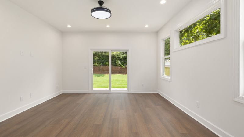 A bright, empty room with a sliding door onto a garden