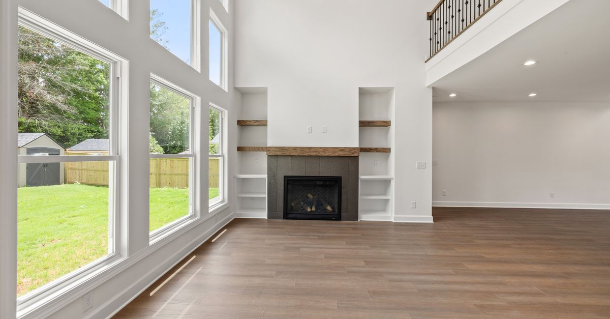 Bright modern living room with large windows and hardwood floors.