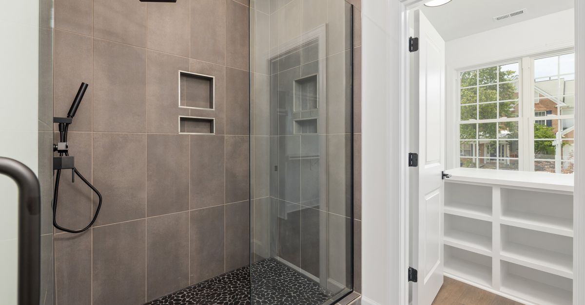 Stylish bathroom showcasing a glass-enclosed walk-in shower with a slate floor and tile walls.