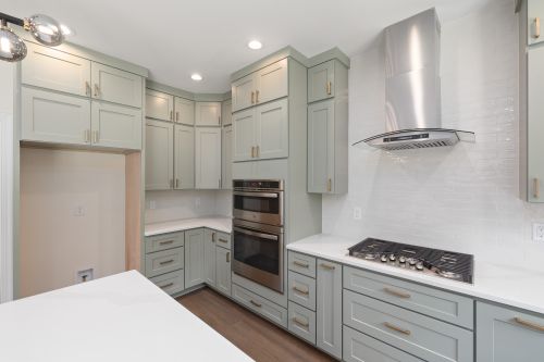 Free Sleek modern kitchen design with stainless steel appliances and green cabinets. Stock Photo