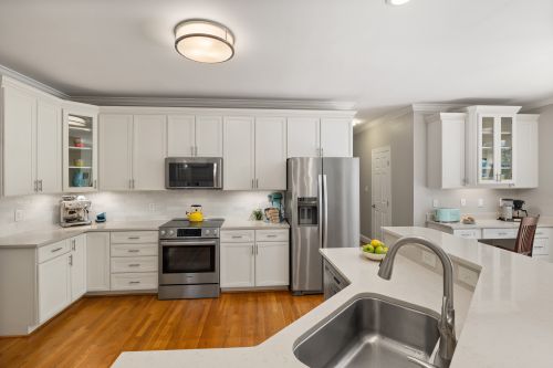 Free Bright modern kitchen with white cabinetry and stainless steel appliances, offering a sleek and clean look. Stock Photo