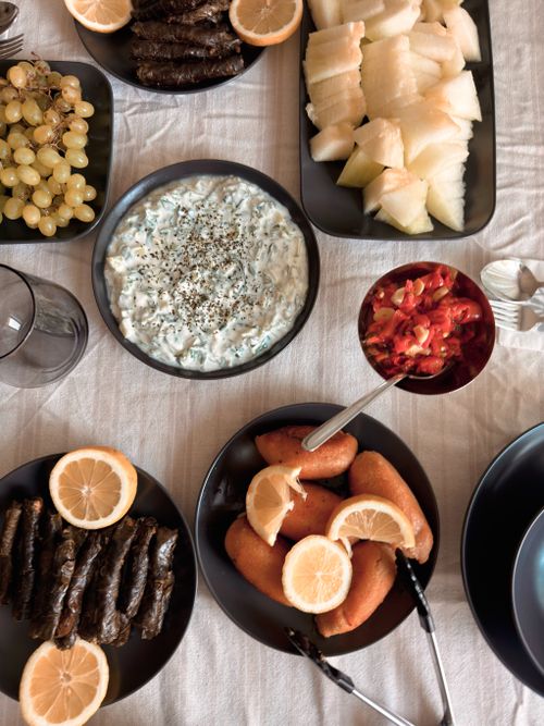 Free A vibrant selection of Mediterranean mezze dishes including falafel, tzatziki, stuffed grape leaves and fresh fruits. Stock Photo