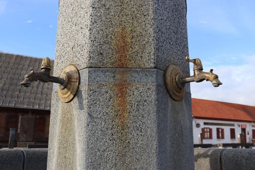 Free Close-up of an ornate stone fountain with vintage brass taps in an outdoor setting. Stock Photo