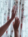 Photo of Person touching Curtains