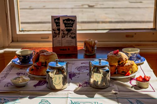 Free Inviting afternoon tea setup with scones and tea in England cafe. Stock Photo