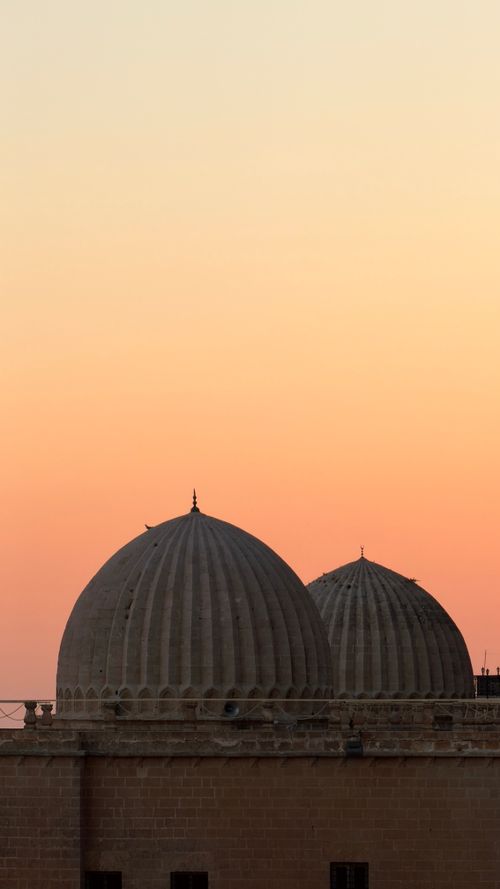 Free Scenic view of historic domes set against a vibrant sunset in Mardin, Türkiye. Stock Photo