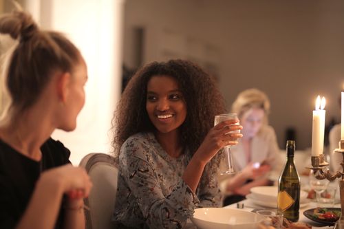 Free Happy friends enjoying a dinner party with wine and candlelight, capturing the essence of joyful gathering indoors. Stock Photo