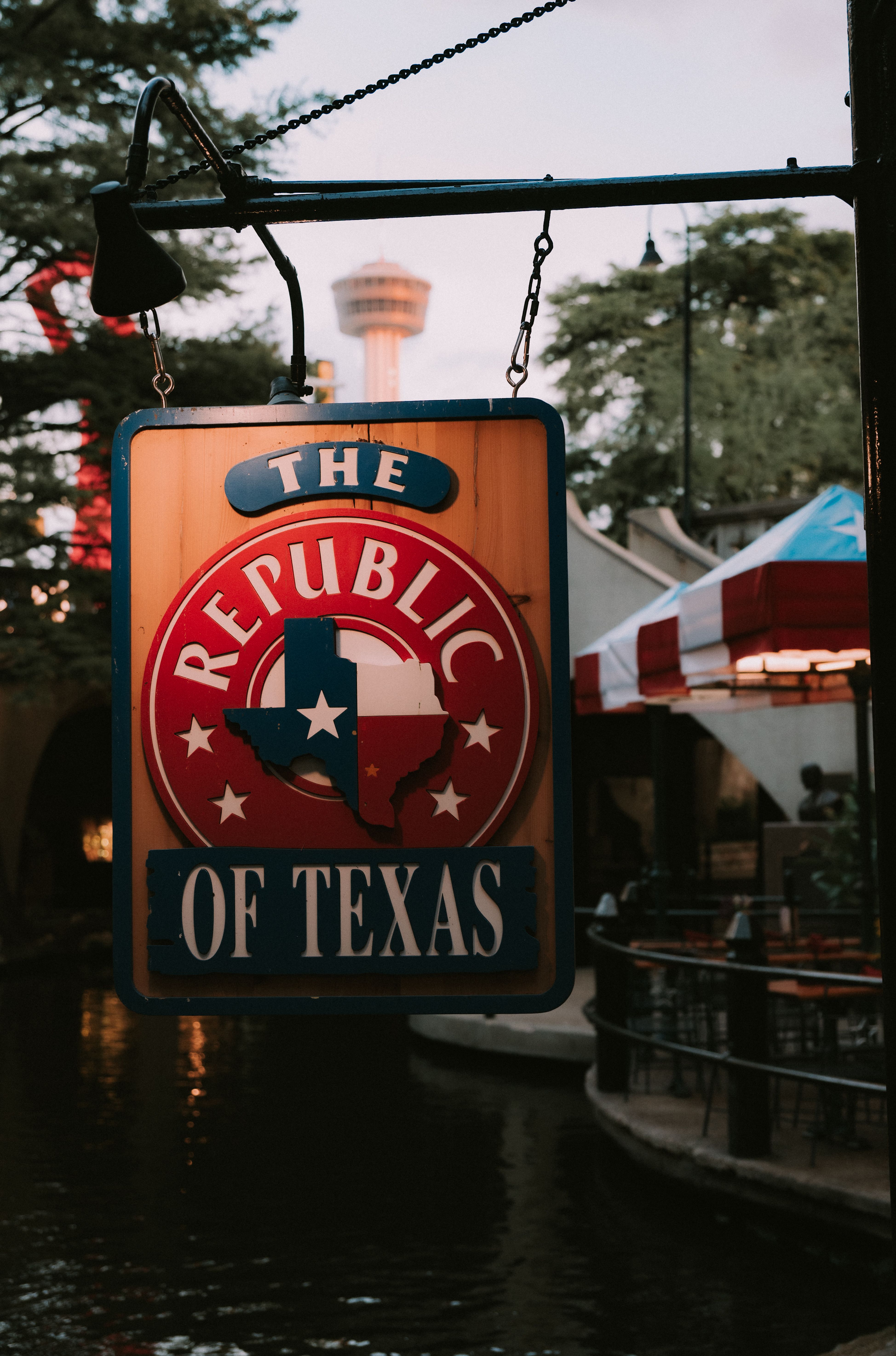 Sign for 'The Republic of Texas' at San Antonio River Walk during twilight, capturing warm evening vibe.
