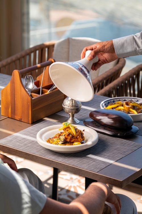 Free Gourmet dish being served in an elegant dining setting with natural lighting. Stock Photo