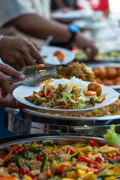 Free Colorful buffet with diverse Asian dishes being served at a lively event. Stock Photo