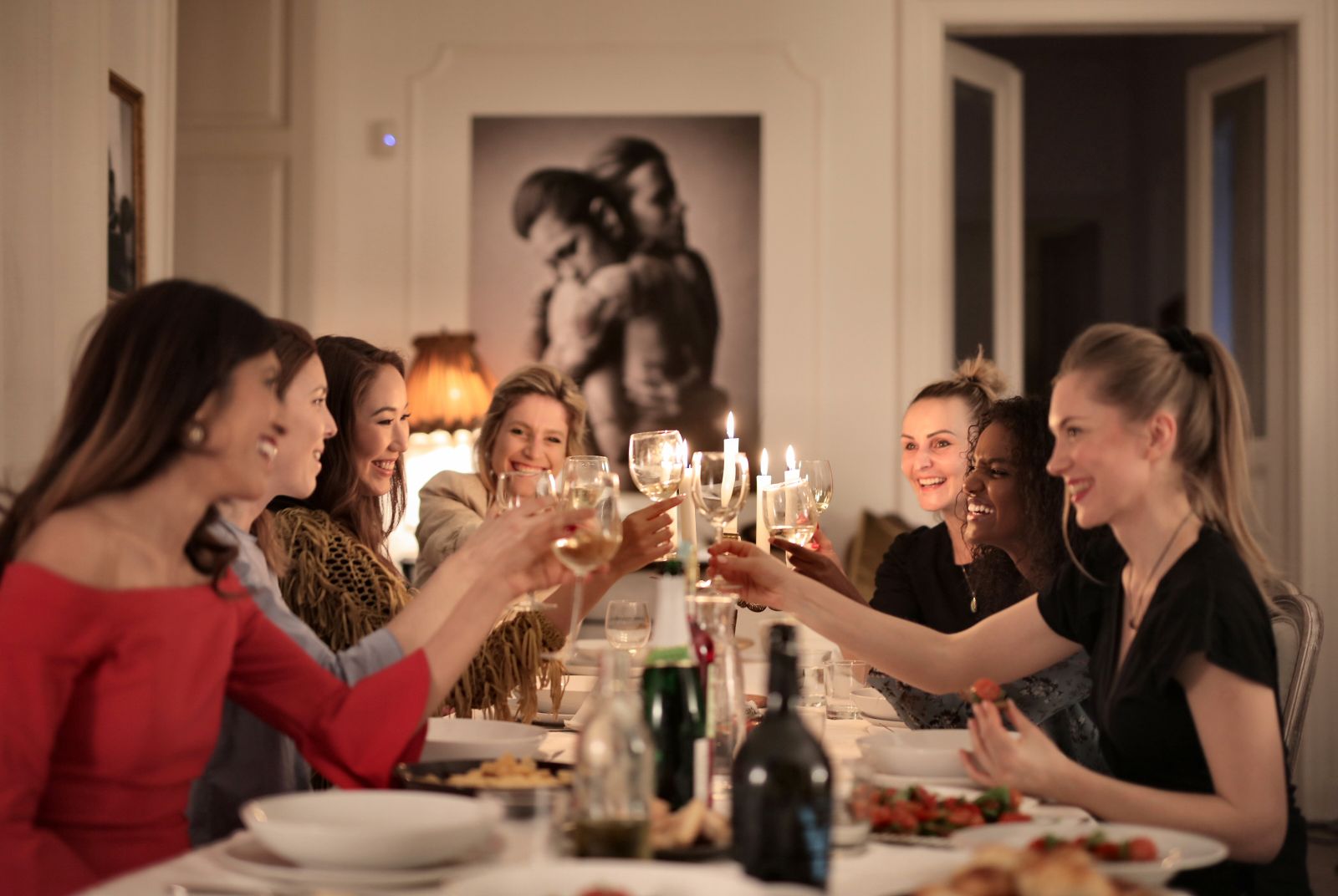 Group of guests seated around a dining table at an evening event Group of guests seated around a dining table at an evening event