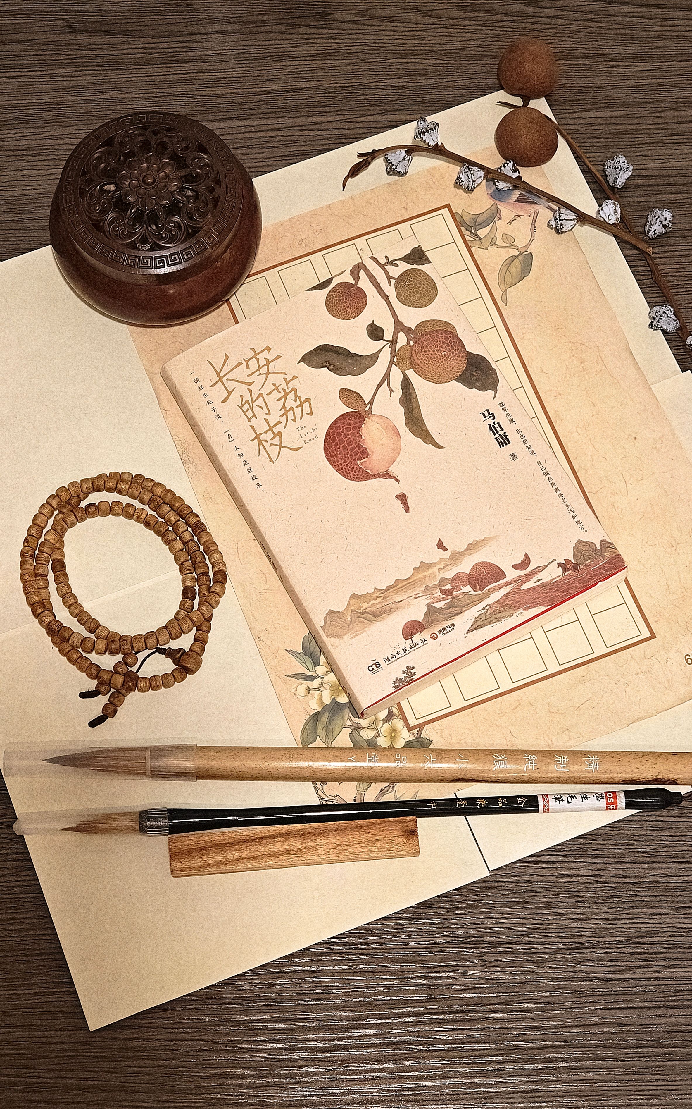 Flat lay of Asian calligraphy set with brushes, incense, and traditional paper art.