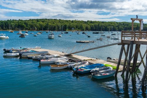 Free Explore a tranquil marina with boats docked by the pier under a blue sky, perfect for summer travel. Stock Photo