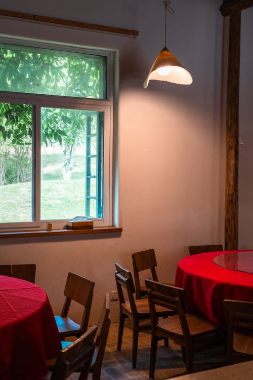 Free Interior of a cozy Chinese dining room with red tablecloths and natural light. Stock Photo