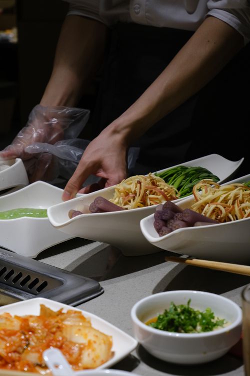 Free Chef prepares Asian dishes with fresh vegetables and sauces in an upscale restaurant setting. Stock Photo