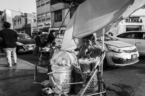 Free A street vendor selling snacks from a cart in a busy market in Trujillo, Peru. Stock Photo