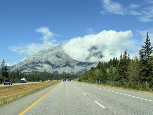 Free Beautiful landscape view of the Canadian Rockies with a clear highway and blue skies. Stock Photo