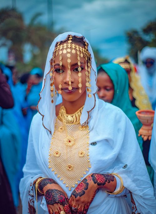 Free Portrait of a woman in traditional attire with elaborate jewelry and henna, captured outdoors. Stock Photo