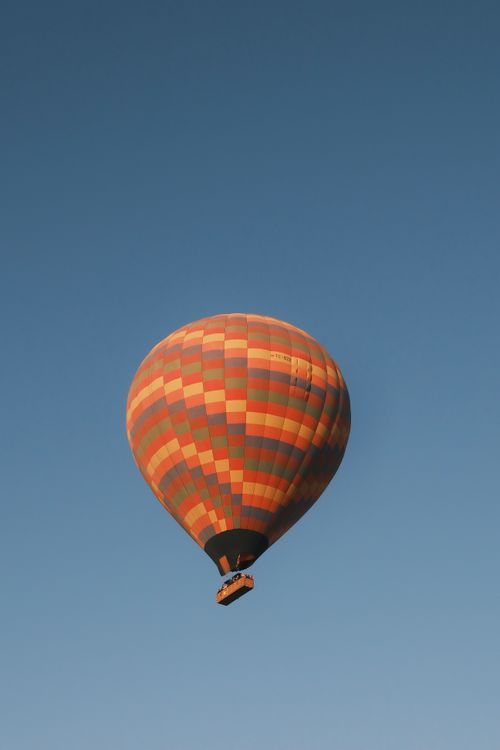 Free Colorful hot air balloon soaring in the blue sky above Göreme, Türkiye. Stock Photo