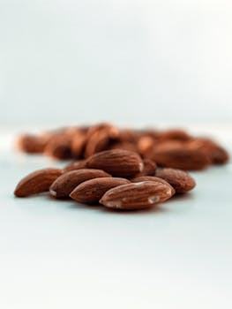 Close-up of fresh almonds on white background, highlighting texture and color.