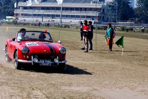 Free A vintage red Triumph convertible participates in a daytime outdoor race event. Stock Photo